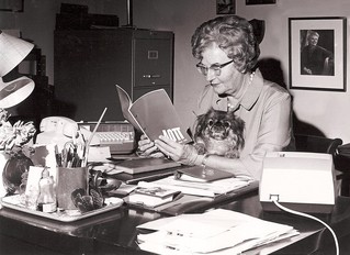 In her office, Dorothy and PooKee review an Alpha Omicron Pi brochure