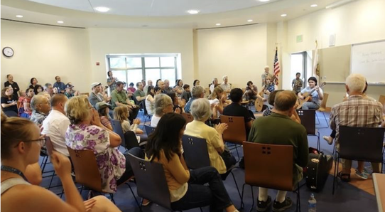 Audience enjoying guitar performance at a local library